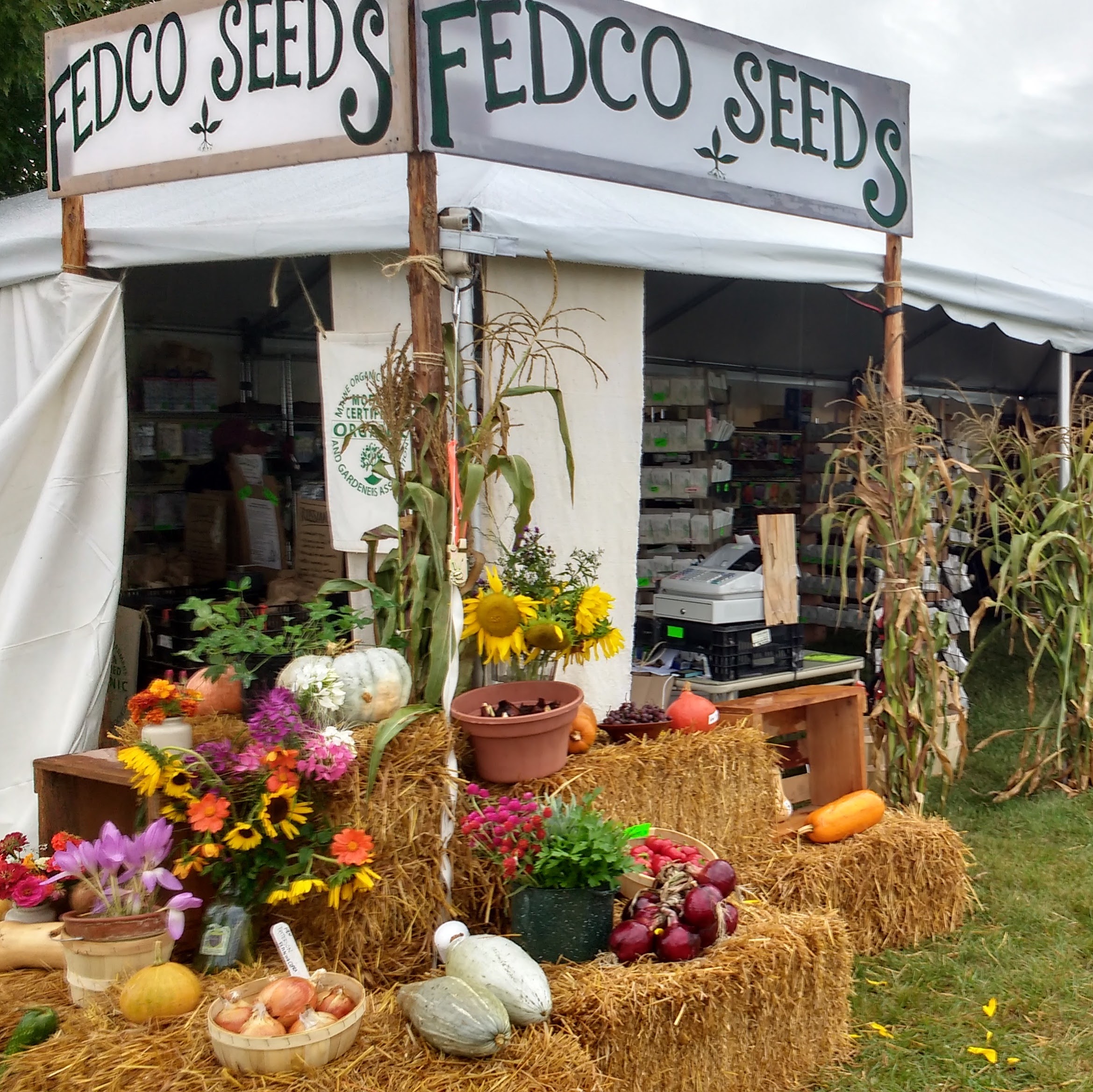 Fedco's booth at the Common Ground Fair, with a bountiful display of vegetables and flowers.